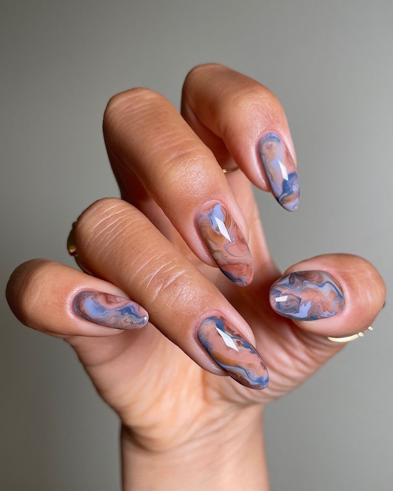 designs ongles marbre bleu et marron sur forme amande