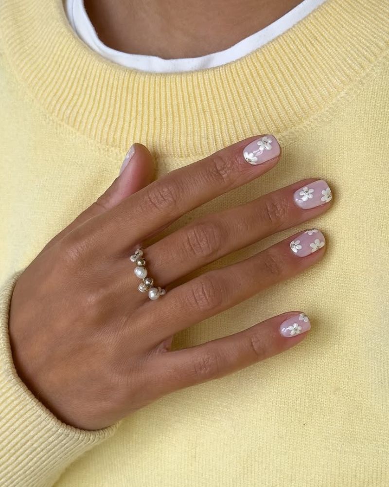 nail art fleur blanche sur base laitée et manucure courte