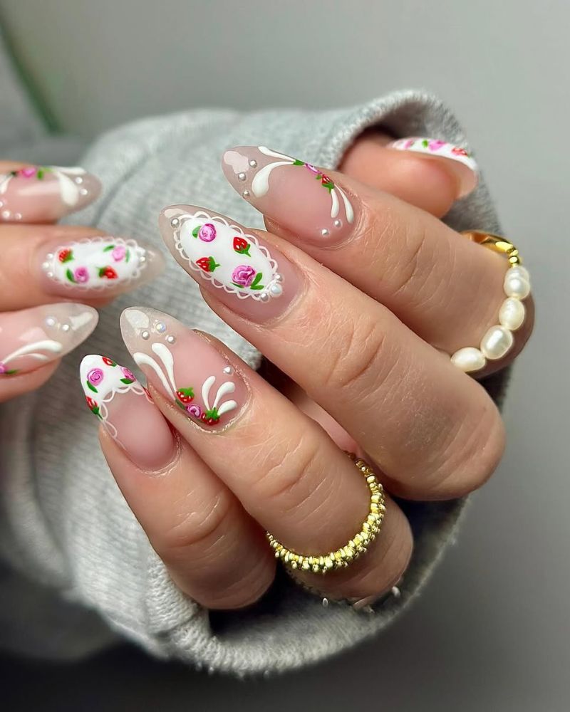 Ongles stilettos simples avec nail art blanc, roses minimalistes et fraises minimalistes