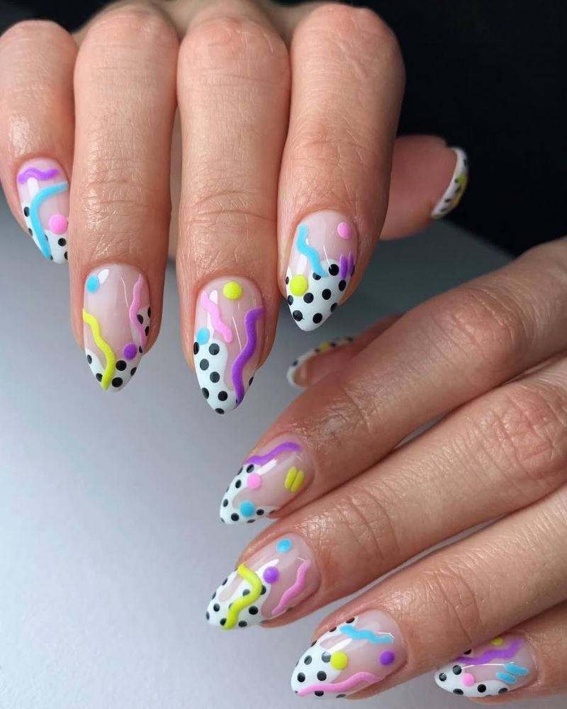 nail art pois noirs sur base blanche et motifs tourbillonnants