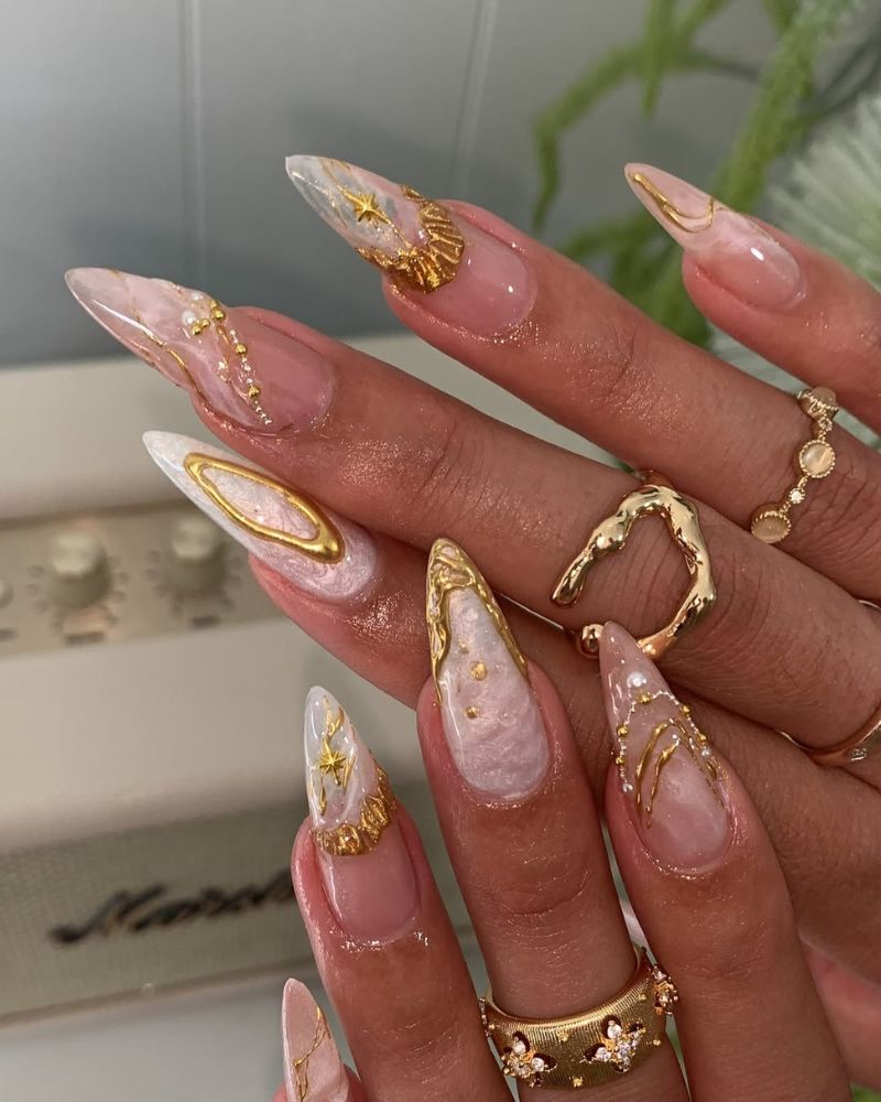 ongles stiletto longs avec nail art marbre blanc et accents dorés