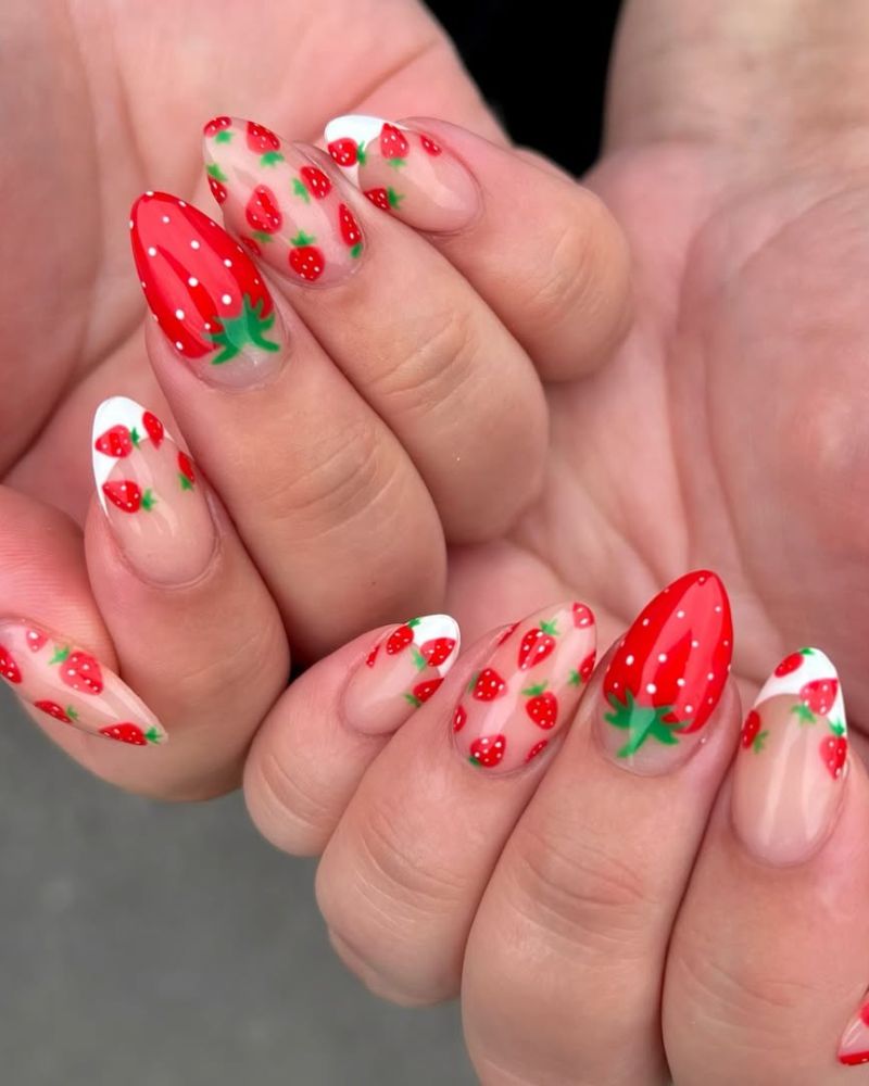 Design fraise rouge sur une manucure nude propre avec extrémité française blanche