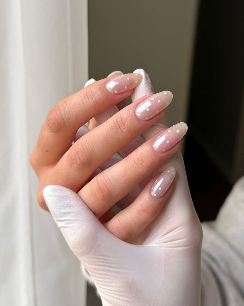 ongles élégants avec pois blancs sur forme amande