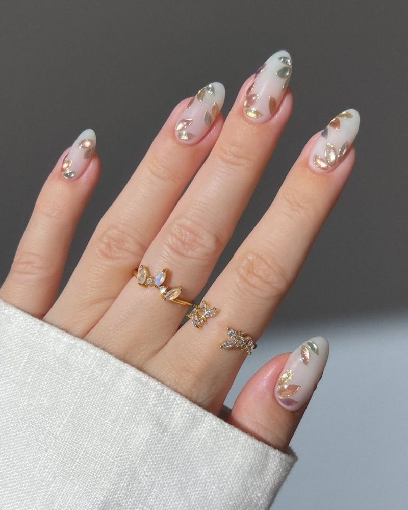 ongles coquettes base blanche laiteuse avec feuilles métalliques