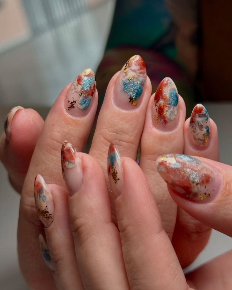 nail art marbre orange, bleu et blanc sur ongles nude