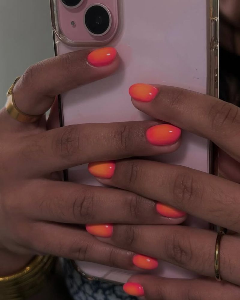 ongles rose vif avec aura orange en nail art coucher de soleil