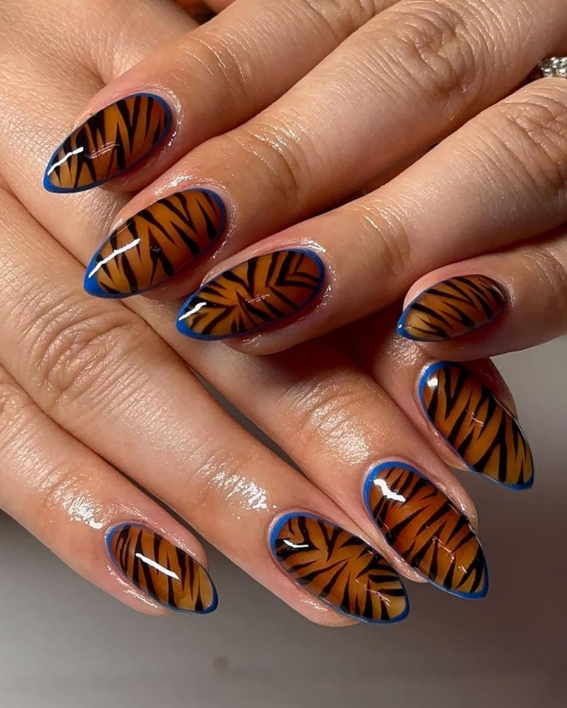 art ongulaire tigre sur ongles gel-x avec contour bleu