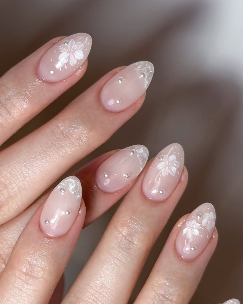ongles délicats de mariée avec base blanc lacté et nail art floral