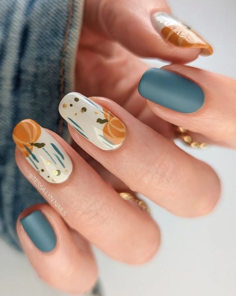 nail art d’automne avec finition mate bleue et citrouille