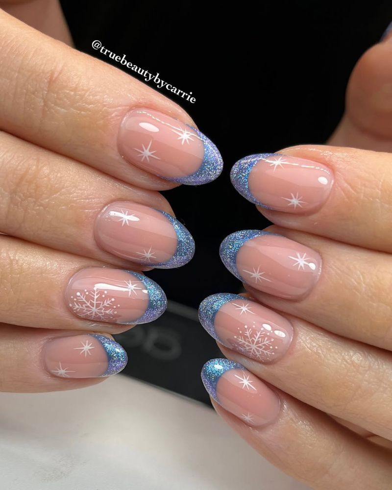 boutons french bleu pailletée sur base nude, avec nail art flocon d’hiver