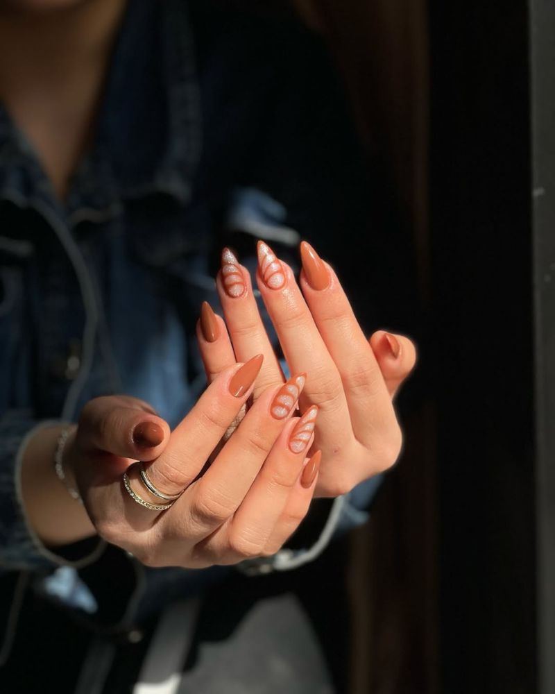 ongles marron clair avec nail art sur forme stiletto lisse