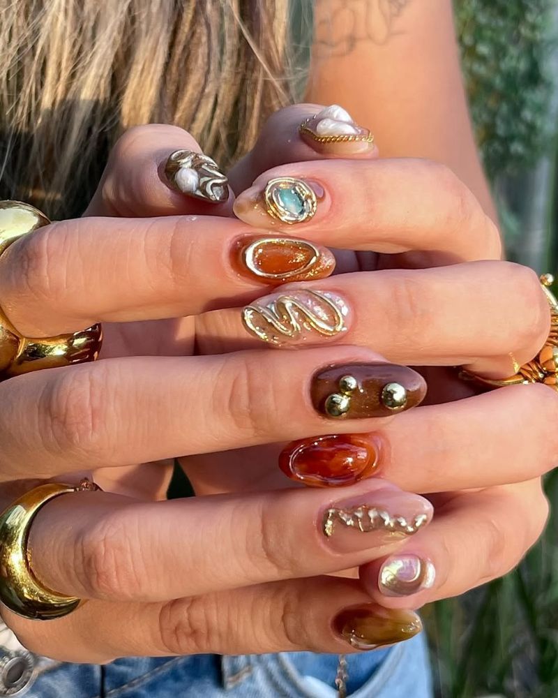ongles marron avec nail art 3D doré pour l'automne, forme amande
