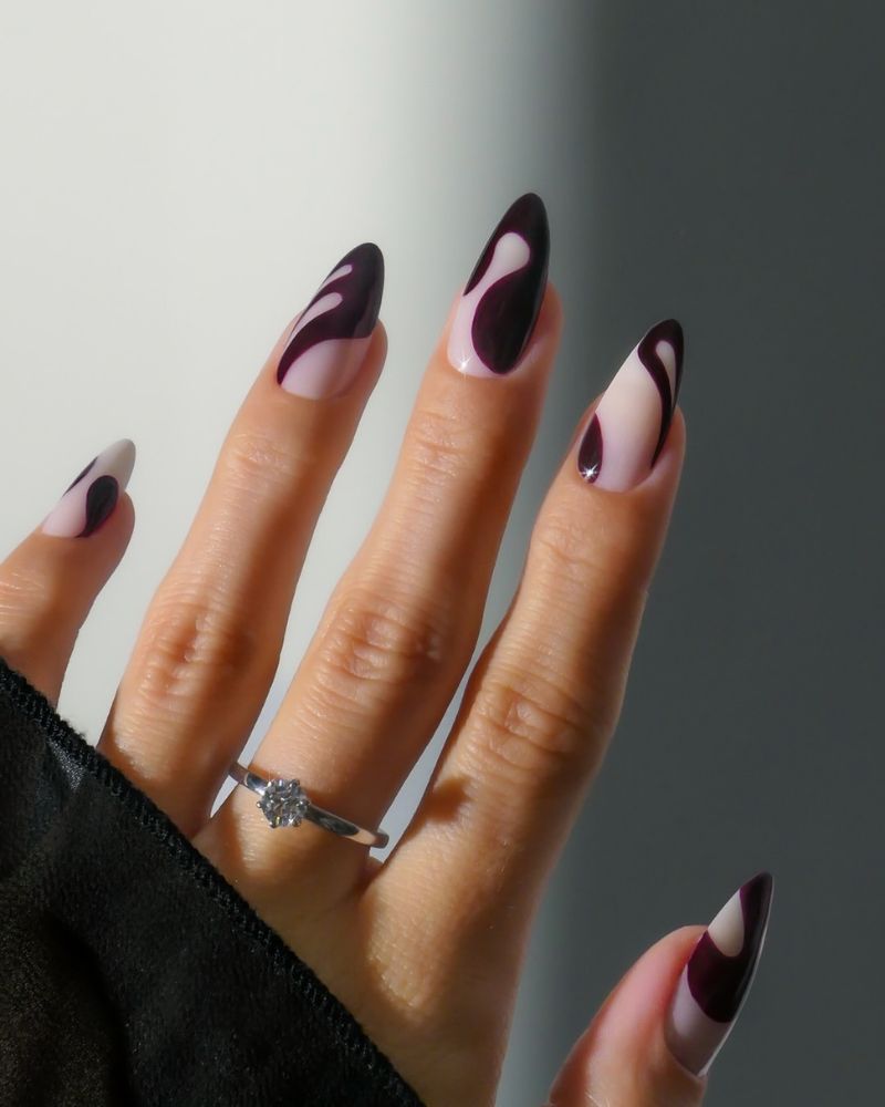 ongles longs en forme amande avec base blanche laiteuse et nail art bordeaux