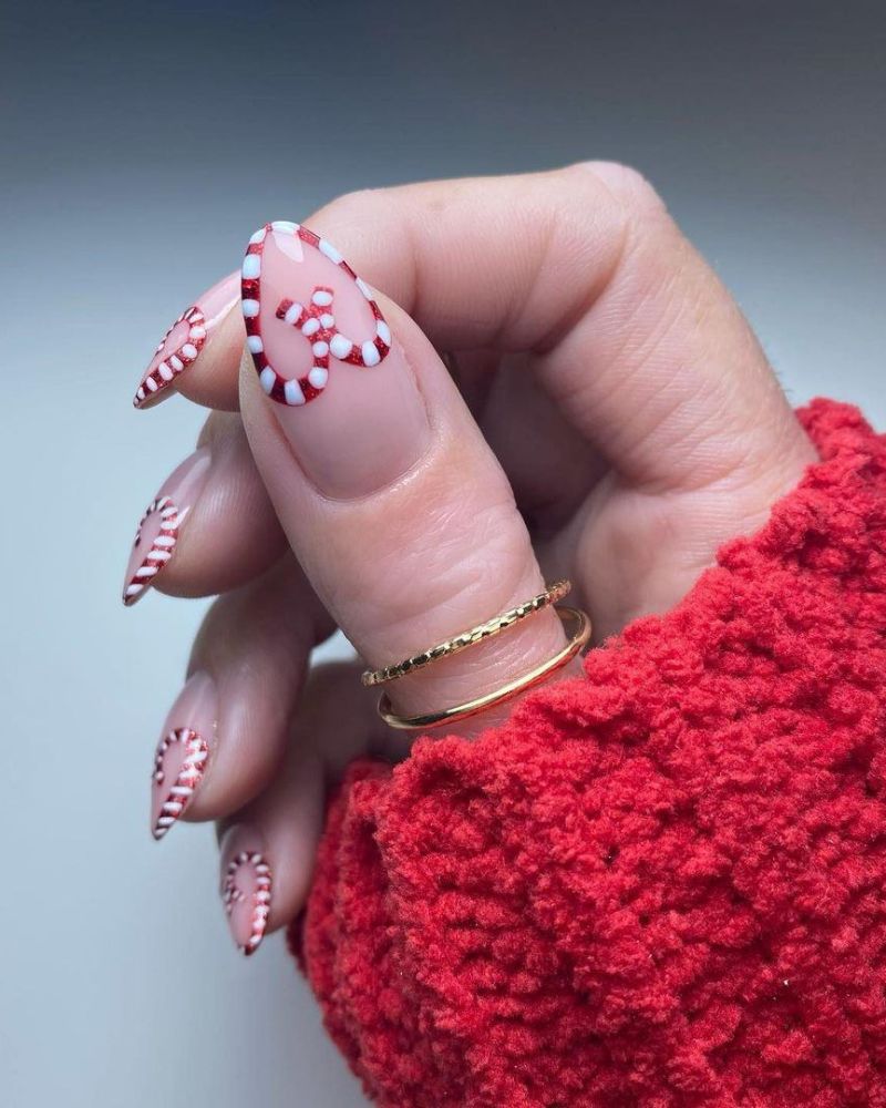 ongles amande longs nude avec cœurs cane de bonbon pour une manucure classe de Noël