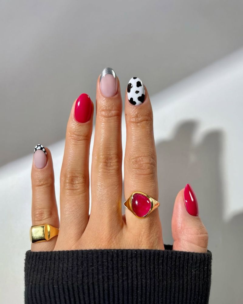 ongles rouges brillants avec nail art imprimé vache, pointes argentées et pois