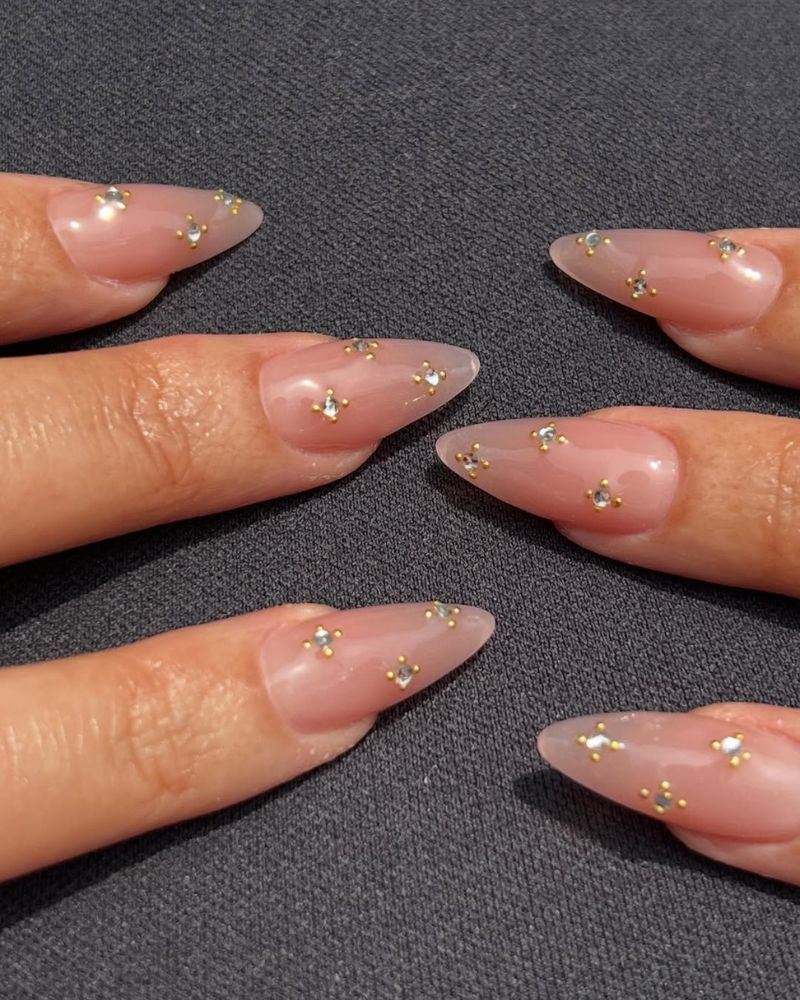 ongles stilettos longs nude avec nail art pierres précieuses