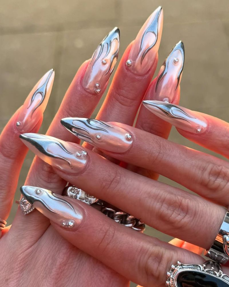 longs ongles stiletto chrome avec nail art flammes argentées