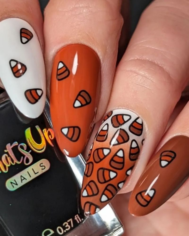 nail art d’automne avec bonbons de maïs sur base blanche, marron et orange brûlé