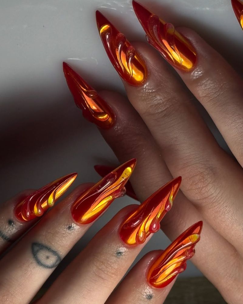 longs ongles stilettos orange chrome avec art 3D transparent