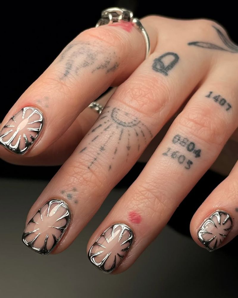 ongles argentés avec nail art fleur sur espace négatif