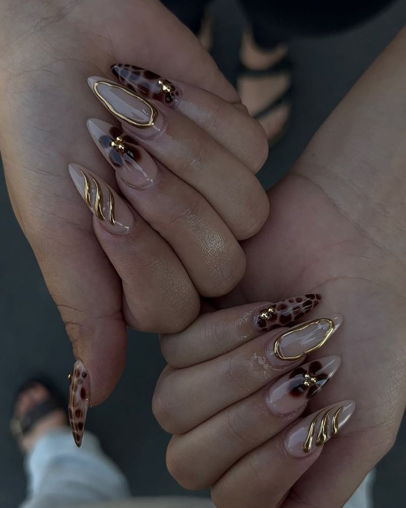 ongles stiletto longs avec nail art marron et doré