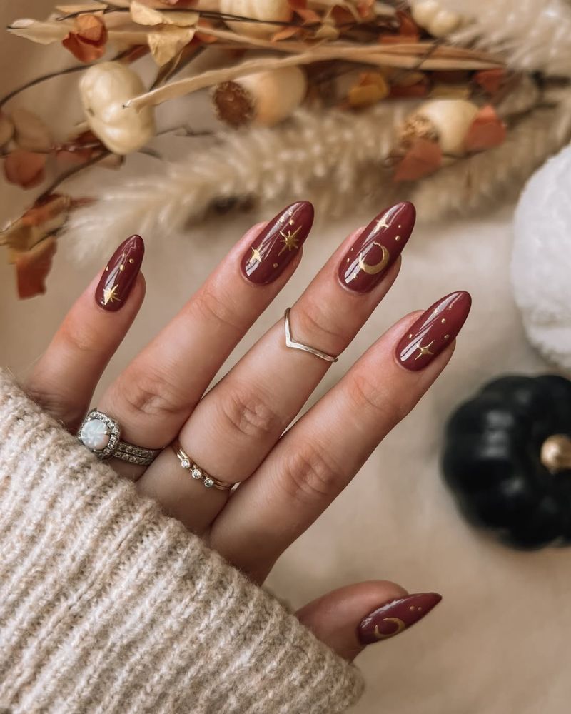 ongles d’automne base bordeaux avec nail art doré