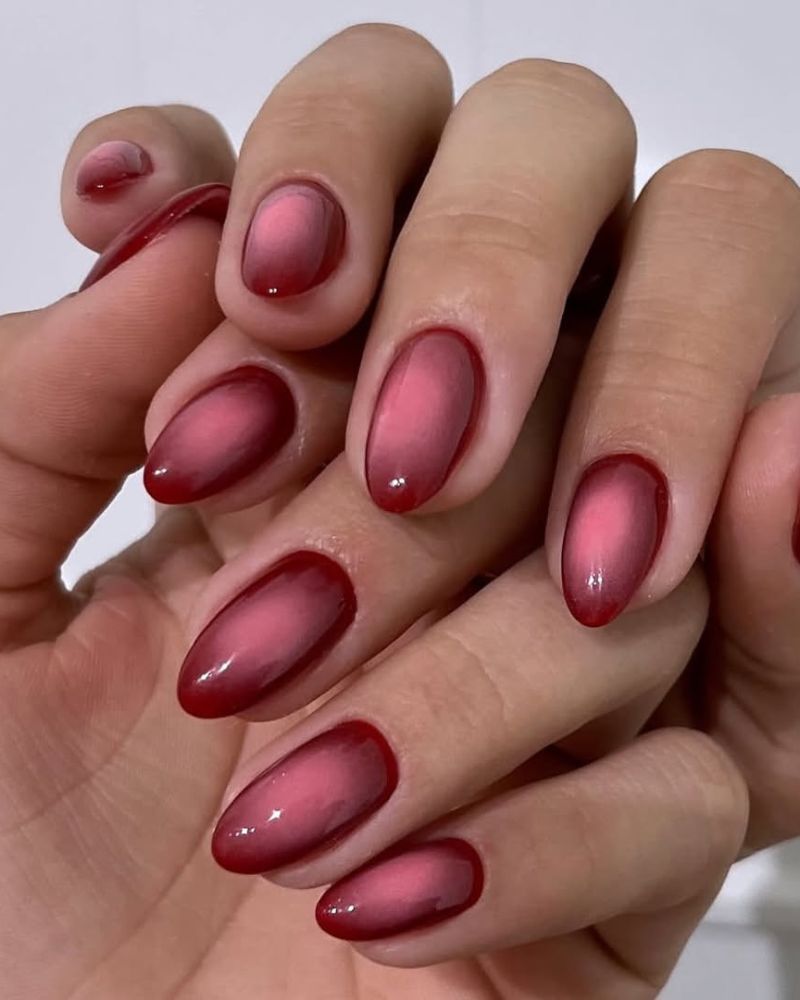 ongles rouges avec nail art aura rose sur forme amande