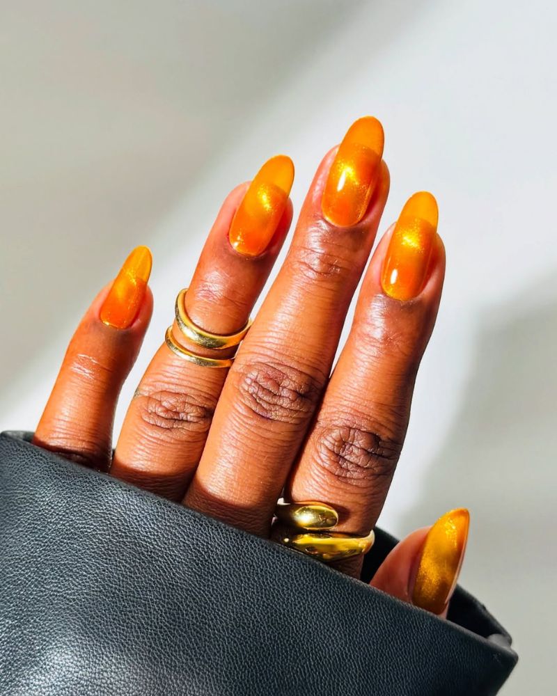 ongles ronds d'hiver avec vernis orange cat eye