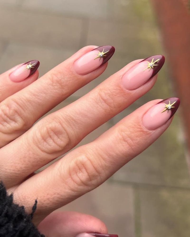 French manucure rouge avec nail art étoile dorée sur forme amande longue