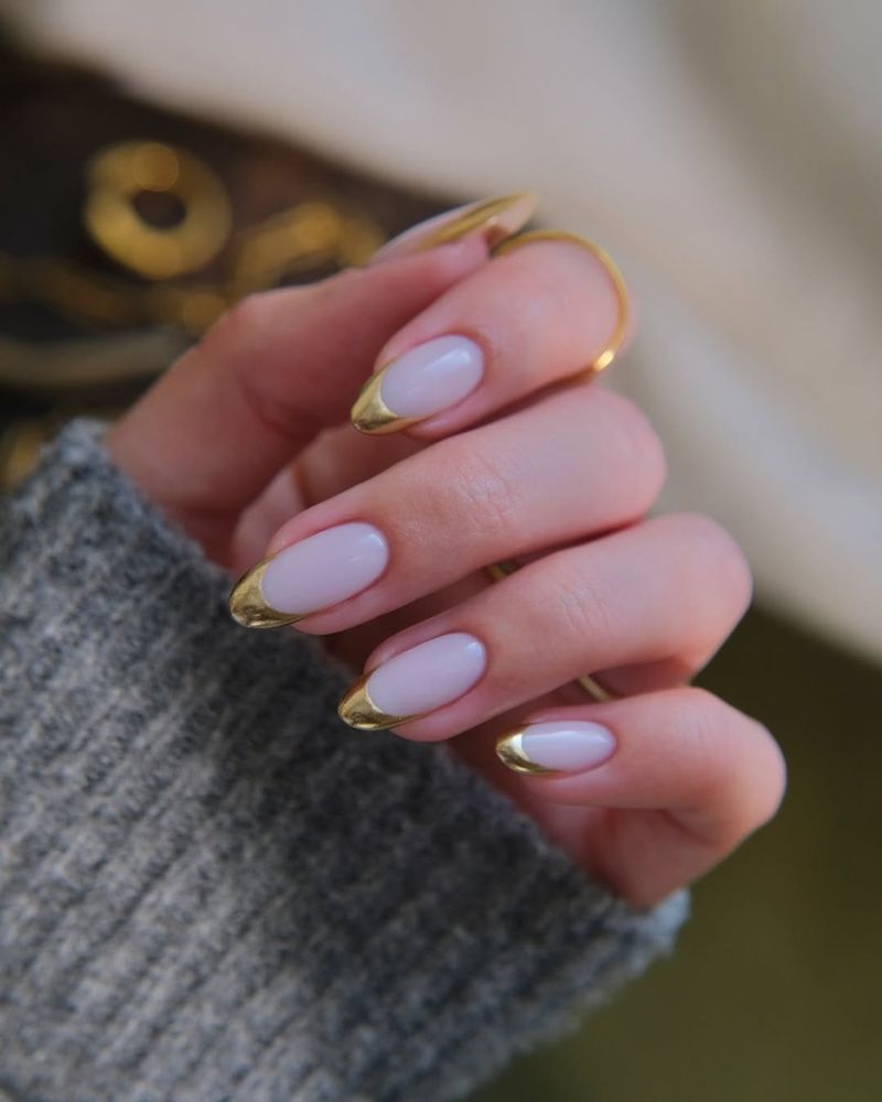 manucure amande avec design français doré sur base blanche opaque