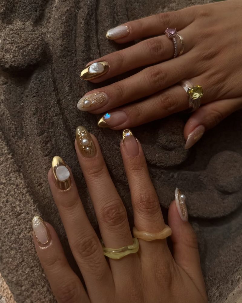 design d’ongles dorés avec pierres précieuses sur base nude naturelle