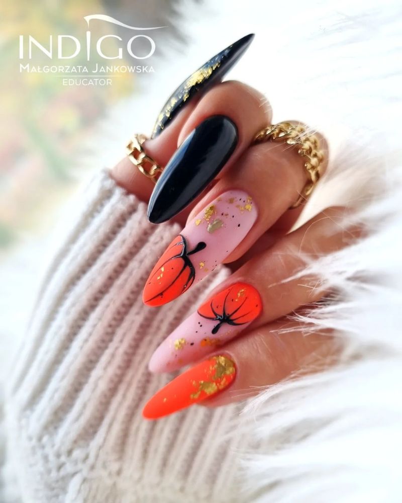 ongles longs néon orange et noir avec nail art d’automne