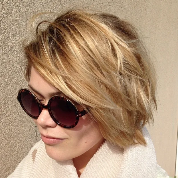 Carré blond choppy avec raie marquée sur le côté et highlights