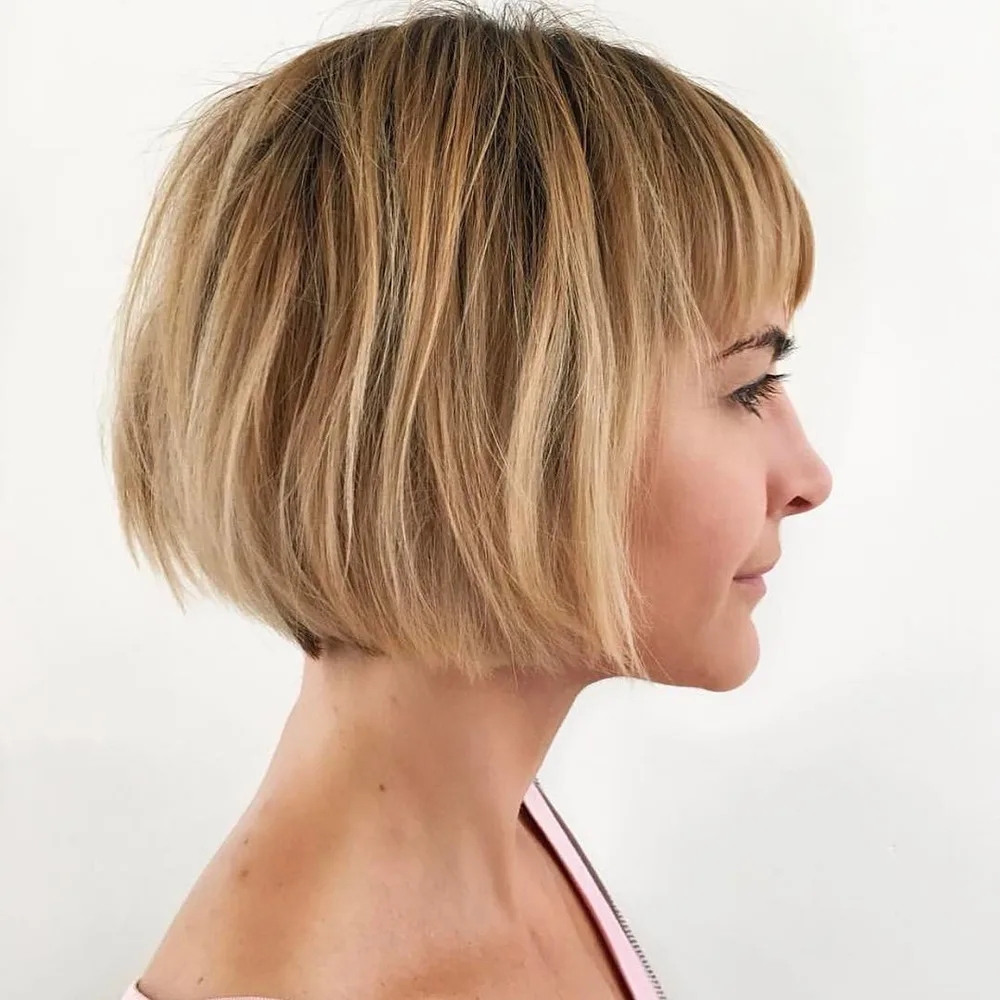 Carré court blond avec frange nette encadrant le regard