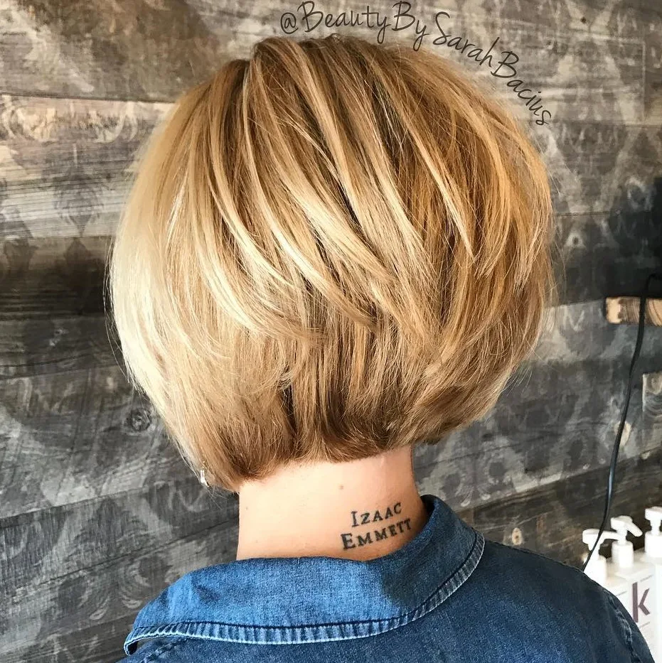 Carré inversé court blond fraise avec nuque empilée et volumineuse
