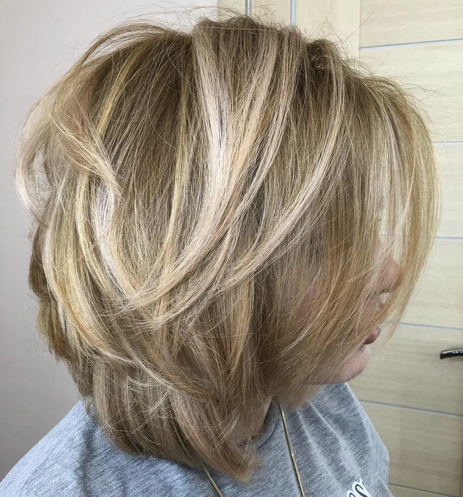 Carré long blond avec brushing blowout volumineux et reflets