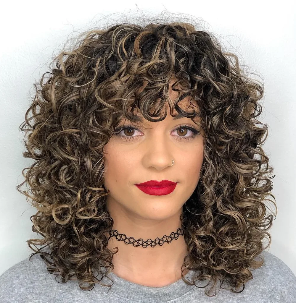 Cheveux bouclés mi-longs avec frange bouclée épaisse
