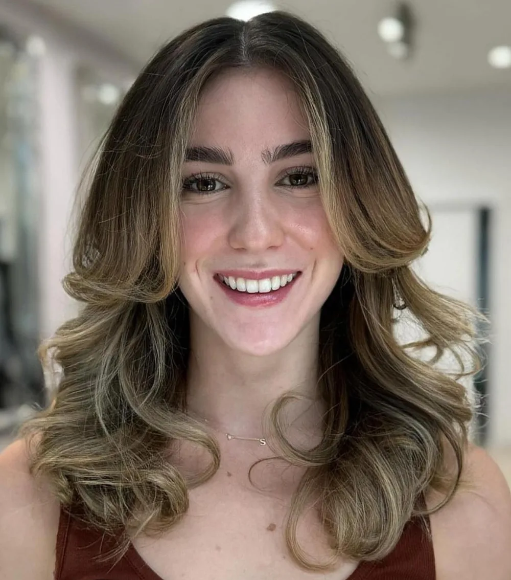 Cheveux châtains balayage ondulés avec frange rideau