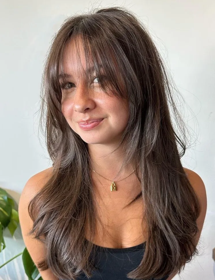 Cheveux longs bruns avec frange rideau souple et dégradé fondu