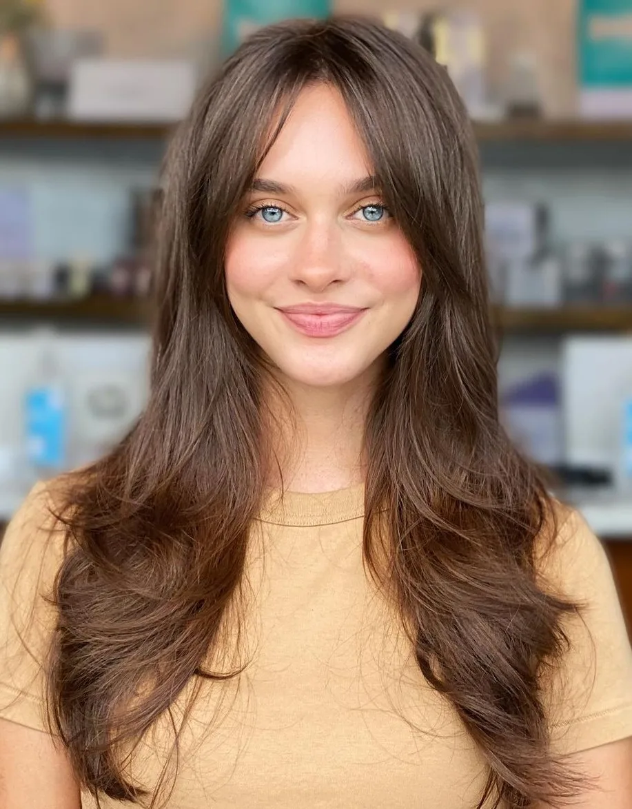 Cheveux longs bruns avec mèches encadrantes et frange rideau