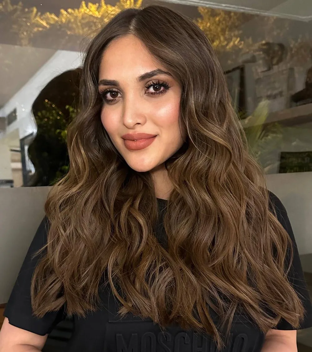 Cheveux longs ondulés brun chaud avec raie au milieu