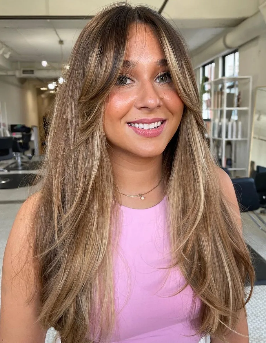 Cheveux raides avec balayage sun-kissed, dégradés doux et frange rideau