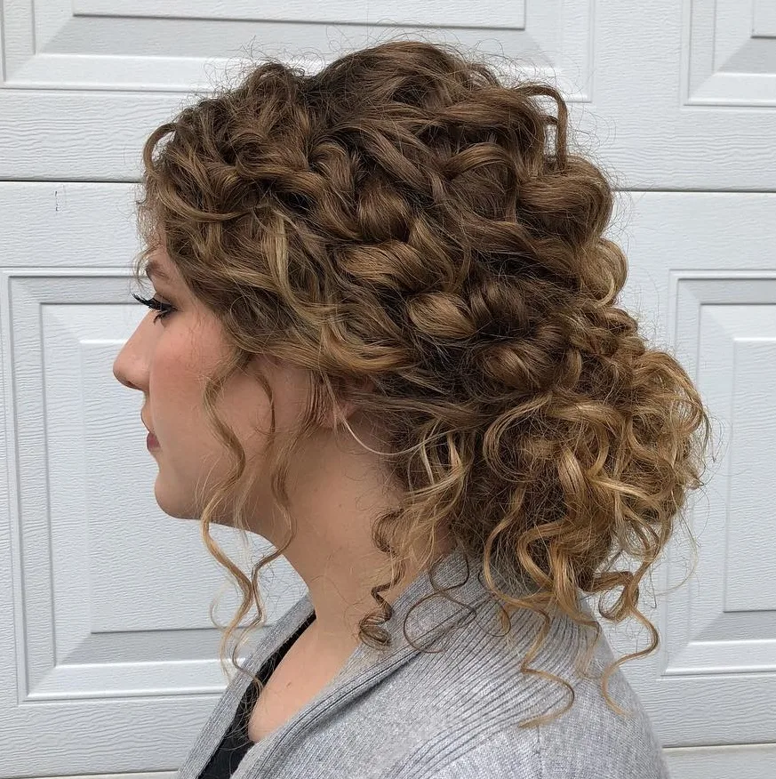Chignon bas bouclé avec tresses lâches sur les côtés