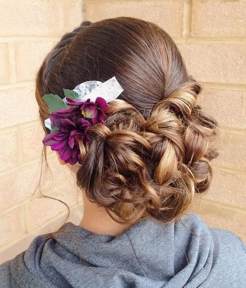 Chignon bas bouclé orné de vraies fleurs
