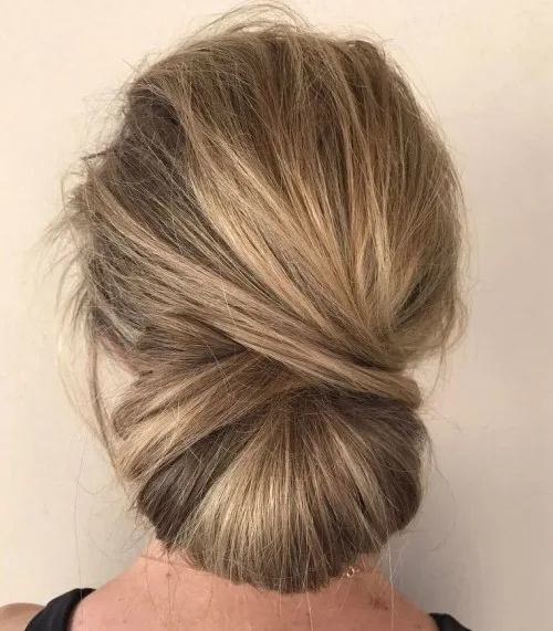 Chignon bas flou et vaporeux avec léger bouffant