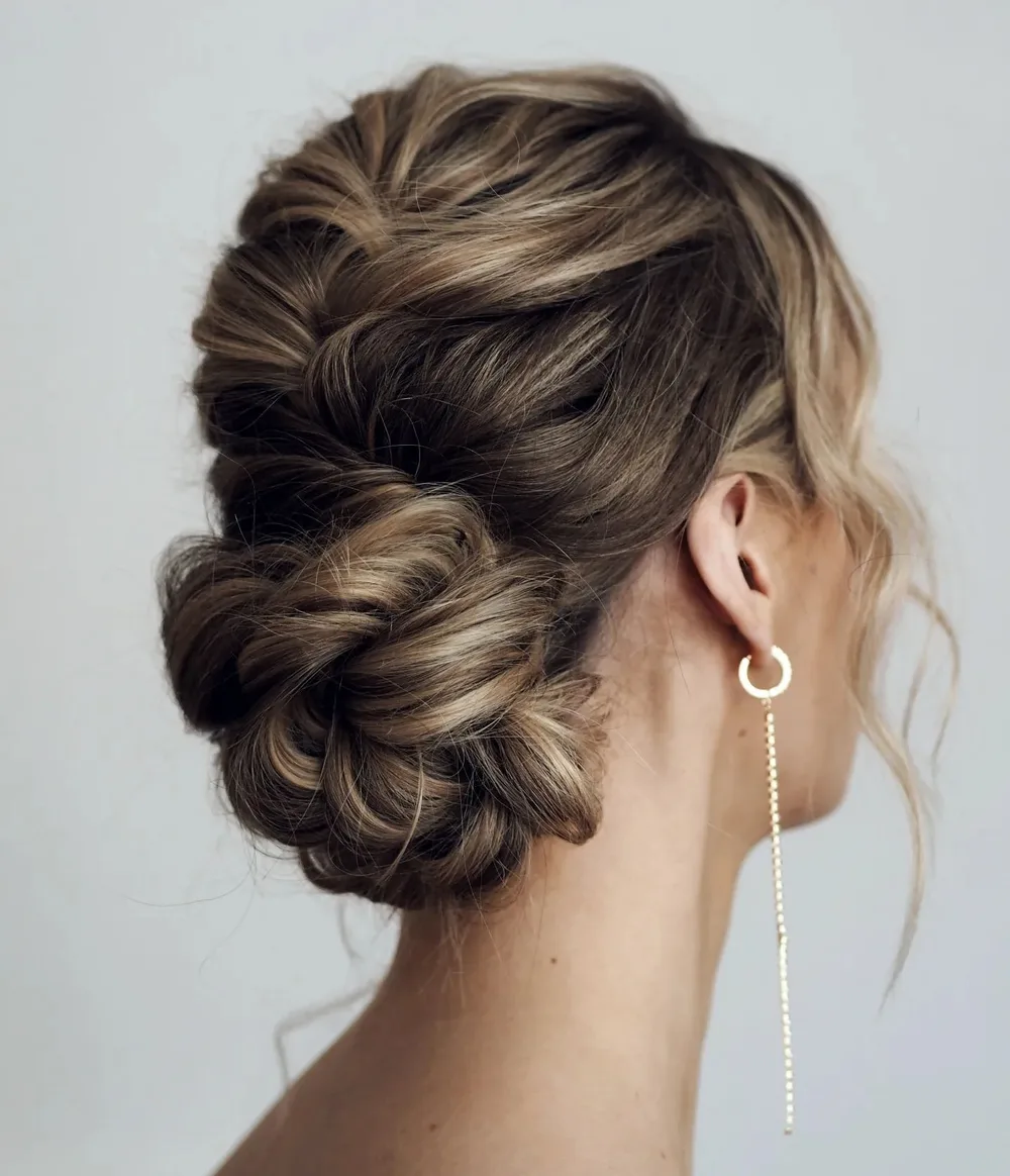 Chignon de nuque avec tresse française et boucles d'oreilles pendantes