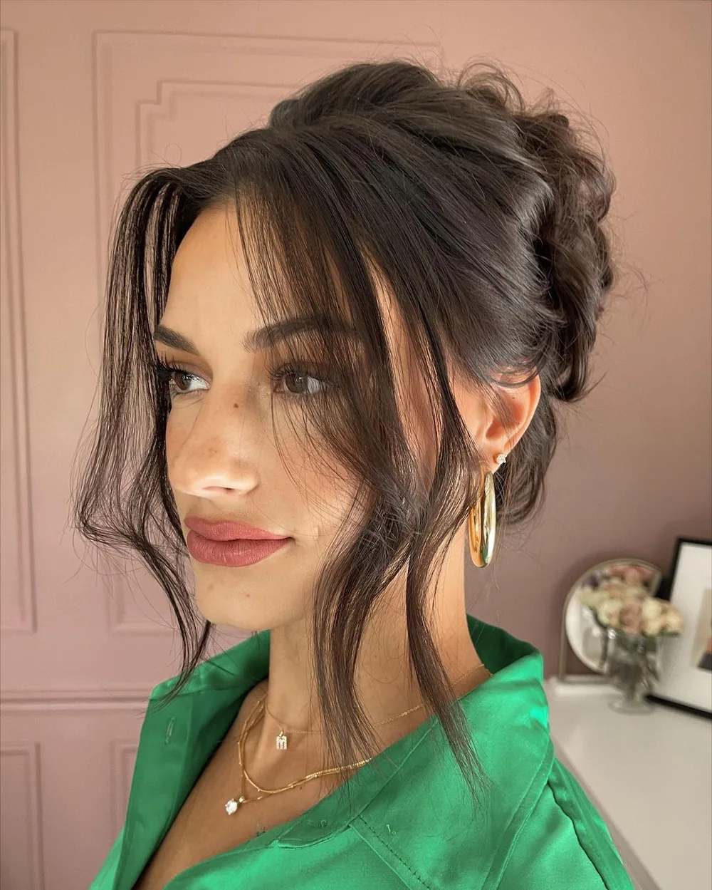 Chignon haut avec mèches libres de chaque côté du visage