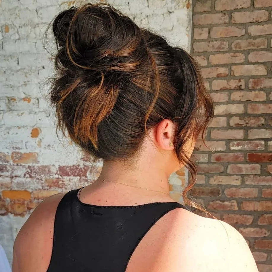 Chignon haut flou et décoiffé avec quelques mèches lâchées devant