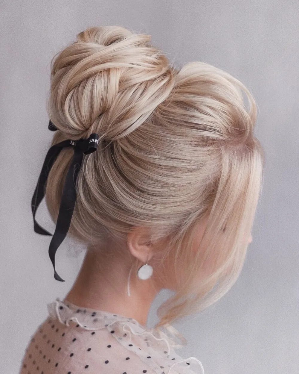 Chignon haut sur cheveux longs orné d'un ruban