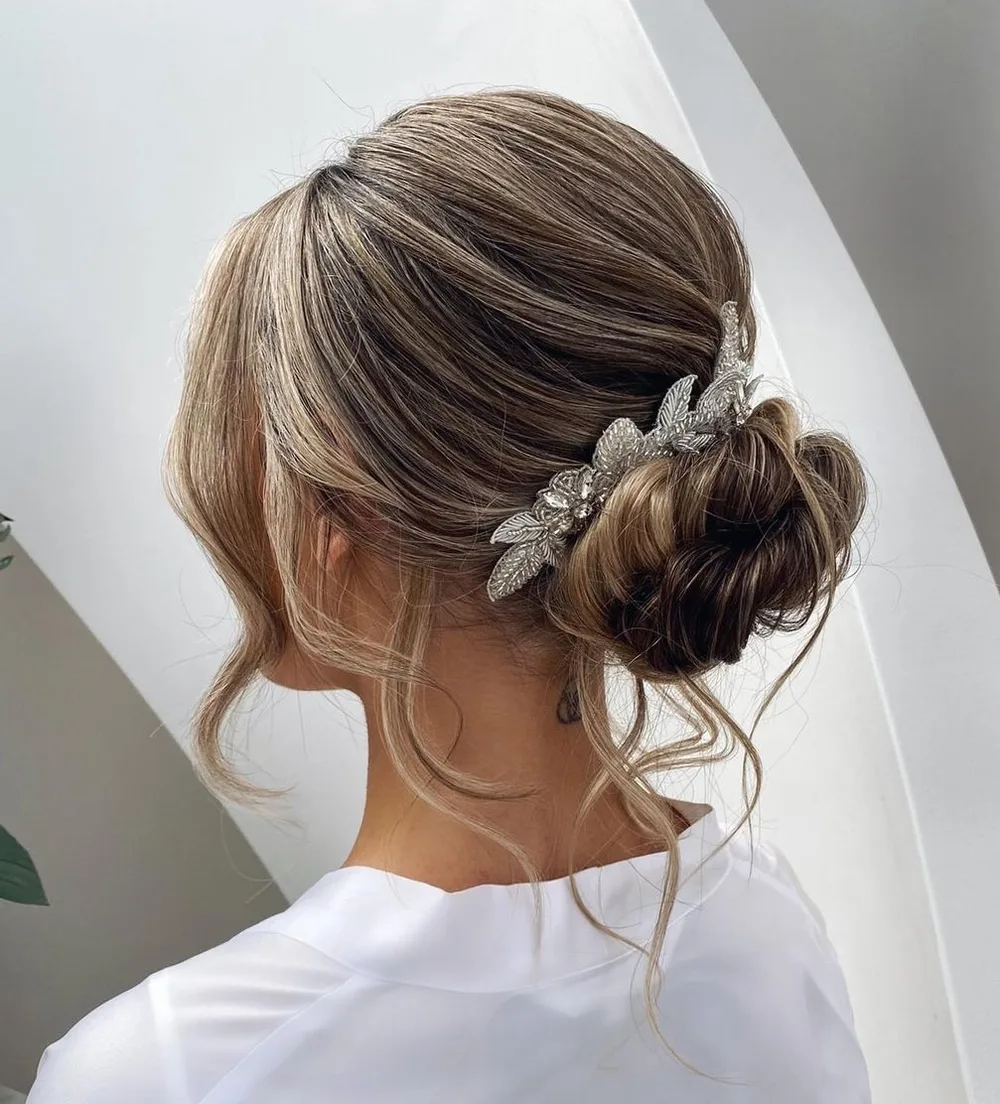 Chignon torsadé de nuque pour mariée avec mèches libres